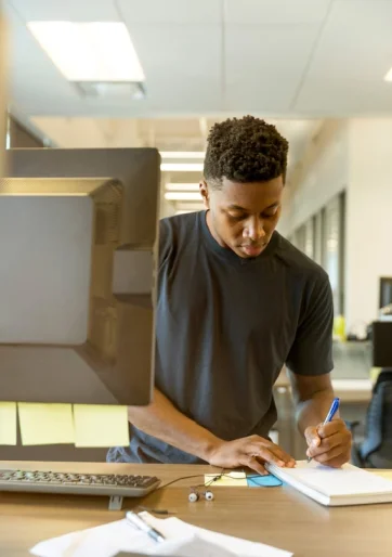 UI designer sketching a website wireframe on paper with a pencil